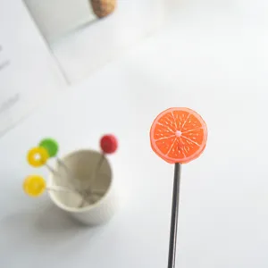 Stainless steel fruit fork with cute resin orange slice decoration, detail view.