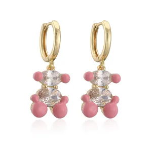 Vue macro détaillée des boucles d'oreilles ours doré avec émail rose et zircons brillants