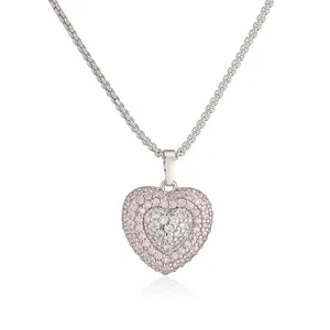 Macro detail of a double-layered heart pendant with pink and white crystals