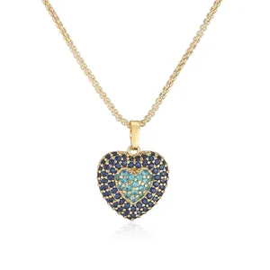 Close-up of a double-layered heart pendant necklace with blue pavé stones and gold chain