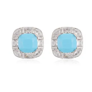 Close-up detail of luxury square stud earrings with blue stone and micro-pave crystals