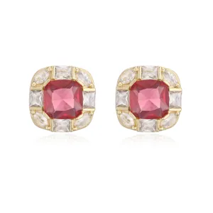 Close-up of elegant gold plated square stud earrings with pink center stone and crystals