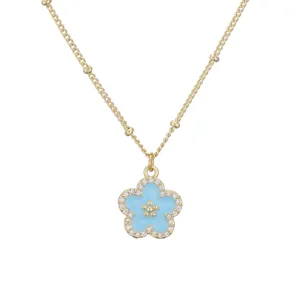 Detailansicht der Goldkette mit blauem Emaille-Blütenanhänger und funkelnden Zirkonen