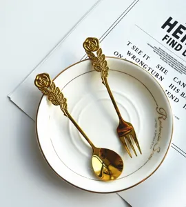 Detailansicht goldener Dessertlöffel und Kuchengabel aus Edelstahl mit Rosen-Design