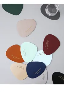 Close-up detail of irregular leather coasters in various colors with gold foil