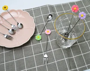 Gros plan sur un ensemble de fourchettes et cuillères à dessert fleuries en inox