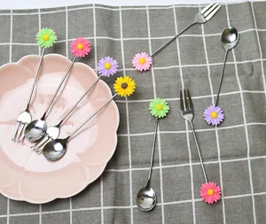 Vue détaillée de cuillères et fourchettes en inox avec des breloques fleurs