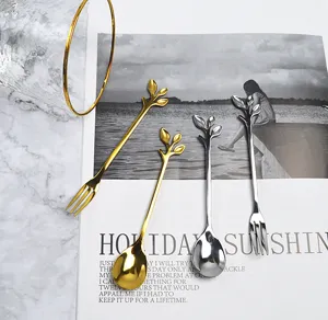 Detail of gold and silver stainless steel spoons and forks with leaf-shaped handles