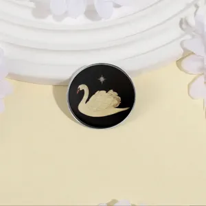 Eleganter runder Metall-Anstecker mit weißem Schwanenmotiv auf Schwarz