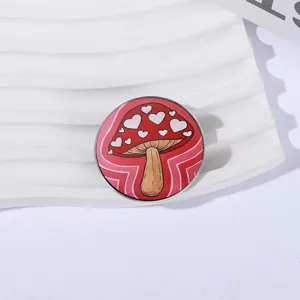 Spilla in metallo a fungo rosso con motivo a cuore bianco su un distintivo circolare