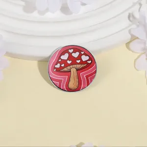 Spilla tonda in metallo con fungo rosso e decorazioni a forma di cuore bianco