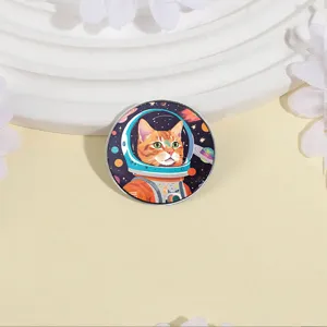 Circular metal badge featuring a cute ginger cat astronaut in space theme design.
