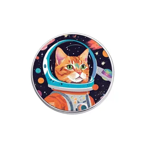 Circular metal brooch featuring an orange cat astronaut in a colorful outer space scene