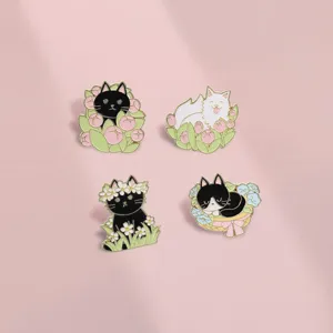 Detailed view of four cute enamel pins featuring black and white cats in spring flowers
