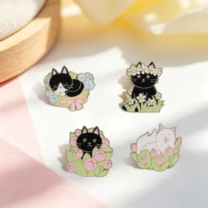 Close-up of four cute cartoon cat enamel pins with floral and spring themes