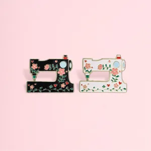 Detailed view of vintage floral sewing machine enamel pins in black and white finishes