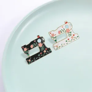 Detail of black and white vintage sewing machine brooches with floral enamel patterns