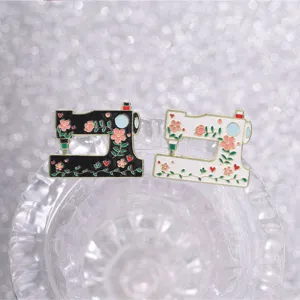 Detailed macro view showing vintage floral sewing machine enamel pins in black and white