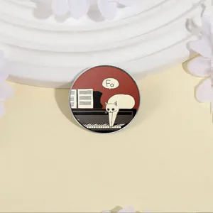 Whimsical round metal brooch featuring a cute white cat on a piano with Fa speech bubble