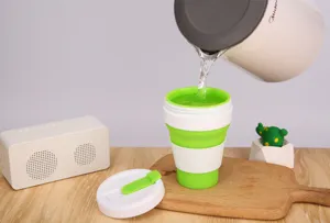 Tazza da caffè pieghevole in silicone verde portatile che viene riempita d'acqua