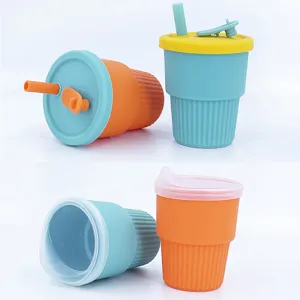 Detailed view of silicone baby straw cups in bright orange and teal colors with lids.