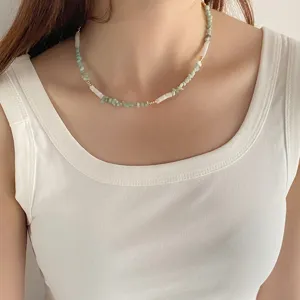 Gros plan d'un collier de perles en pierres naturelles vert menthe et blanc