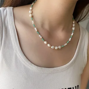 Gros plan détaillé d'un collier de perles naturelles et de perles vert menthe sur un modèle.