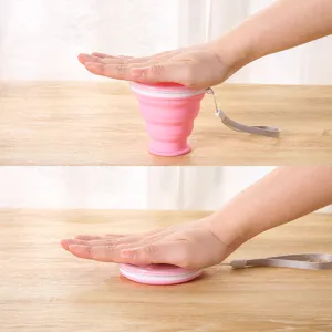 Portable pink collapsible silicone travel cup showing expanded and folded states