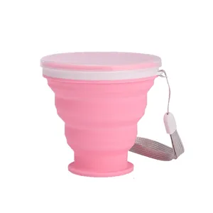 Portable collapsible pink silicone travel cup with lid and gray lanyard strap