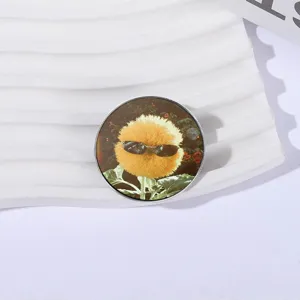 Broche redondo de metal con una flor amarilla esponjosa con gafas de sol