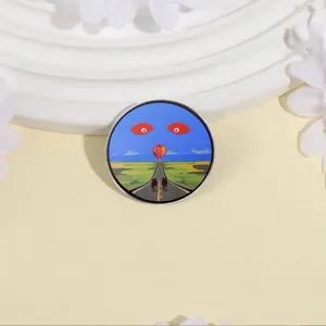 Artistieke ronde metalen broche met een surrealistisch landschap en ogen