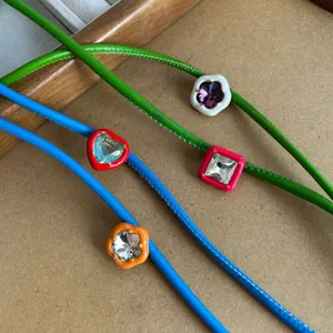 Detailed macro view of colorful leather cord necklaces with heart and flower crystal charms