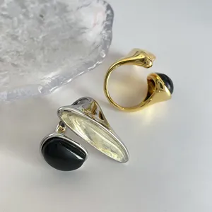 Vista detallada de elegantes anillos ajustables en oro y plata con cuarzo ahumado puro.