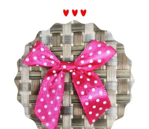 Gros plan d'un nœud en ruban de satin rose à pois pour cadeaux et accessoires divers.
