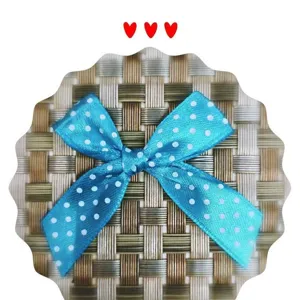 Vue détaillée d'un nœud en ruban de satin bleu à pois pour accessoires de cheveux