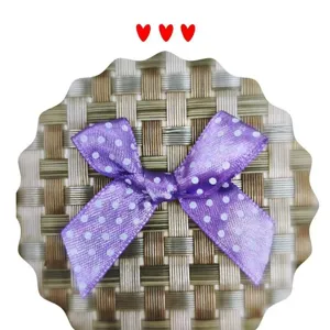 Détail d'un nœud en ruban de satin violet à pois fait main pour emballage cadeau