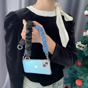 Nahaufnahme von schwarzen Leder- und blauen Denim-Handy-Handgelenkbändern im Scrunchie-Stil