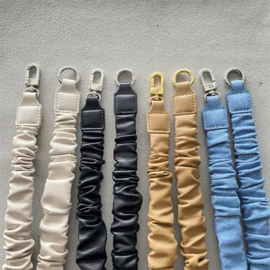 Detailansicht verschiedener bunter Handy-Handschlaufen aus Leder und Denim im Scrunchie-Design