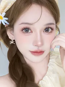 Close-up of sparkling rhinestone and pearl bow earrings on an Asian female model