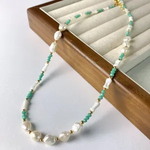 Gros plan d'un collier de perles naturelles avec des perles vert menthe sur bois