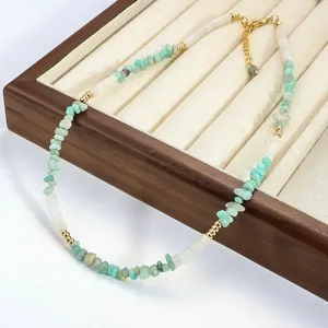 Vue détaillée d'un collier en pierres naturelles vert menthe sur un plateau en bois.