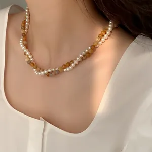 Elegante collana a due fili con perle e grani ambrati indossata da una modella