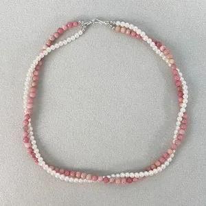 Collana a doppio filo con perle bianche e grani rosa in un elegante design a treccia