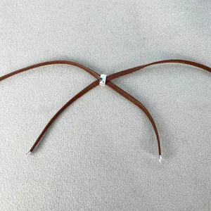 Dettaglio collana in pelle marrone con cursore regolabile in metallo argentato.