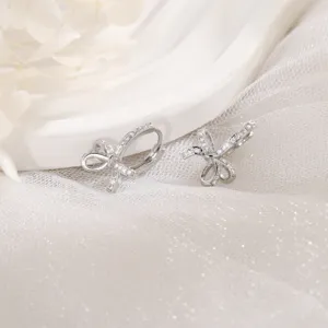Detail of exquisite silver-colored bow earrings inlaid with sparkling cubic zirconia stones