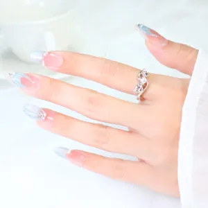 Detailed view of a silver puppy zircon ring with paw design worn on manicured hand