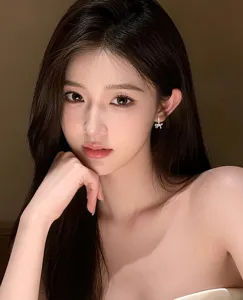 Close-up detail of an Asian model wearing a delicate silver bow earring with sparkling zircons.