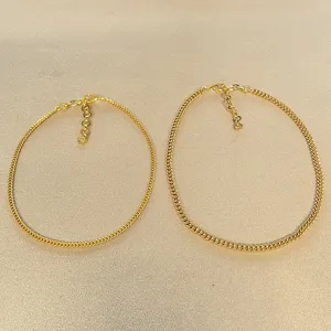 Nahaufnahme von zwei eleganten goldenen Vintage-Panzerketten auf Goldhintergrund.