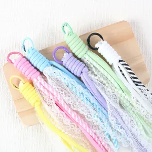 Colorful paracord phone charm with delicate white lace, pearls, and metal hook for DIY decor.