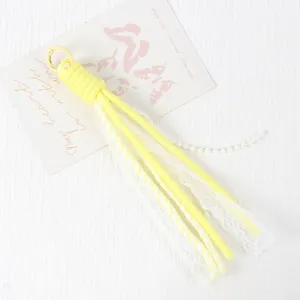 Yellow paracord phone charm with white lace ribbon and pearls for DIY accessories.